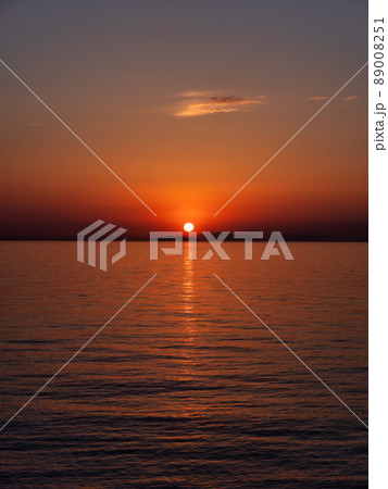 瀬戸内海の島陰に沈む夕日、縦構図 89008251