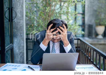 Working Asian men feel stressed, tired from work, migraine headaches from hard work while working at the office Working Asian men feel stressed, tired from work, migraine headaches from hard work while working at the office 89008844