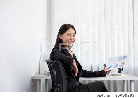 Asian businesswomen sit at their desks and calculate financial graphs showing results about their investments, plan a successful business growth process in the office 89008895