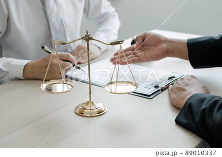 A man lawyer or a judge counseling clients about judicial justice and prosecution with scales, judges gavel, legal documents legal services concept 89010337