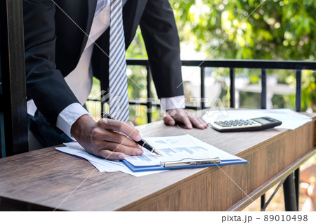Young businessman financial market analyst sits at their desks and calculate financial graphs showing the results of their investments planning the process of successful business growth Young businessman financial market analyst sits at their desks and calculate financial graphs showing the results of their investments planning the process of successful business growth 89010498