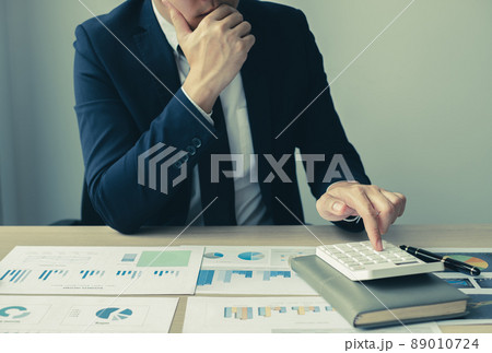 The hand of businessman sit at their desks and calculate financial graphs showing results about their investments, plan a successful business growth process The hand of businessman sit at their desks and calculate financial graphs showing results about their investments, plan a successful business growth process 89010724