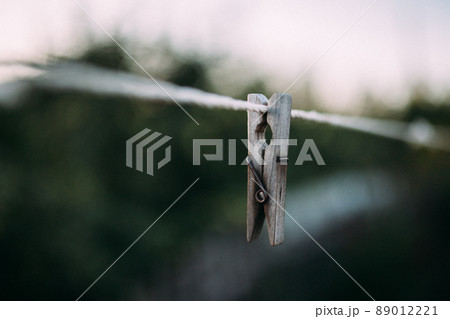 Old wooden clothespegs hanging on rope. 89012221