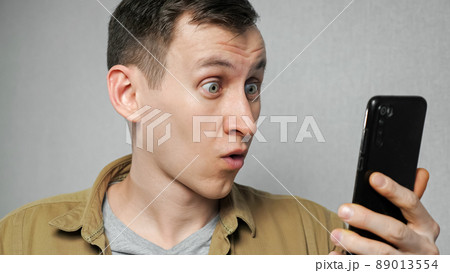 Man removes glasses after reading news on mobile phone Man removes glasses after reading news on mobile phone 89013554