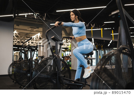 Fitness woman on exercise bike doing cardio workout Fitness woman on exercise bike doing cardio workout 89015470