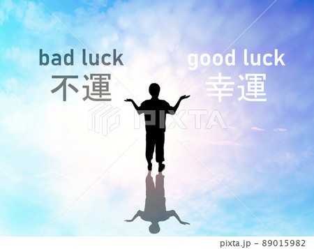 両手を上に向けて立つ男性シルエットと幸運不運の文字_スピリチュアルな空背景 両手を上に向けて立つ男性シルエットと幸運不運の文字_スピリチュアルな空背景 89015982