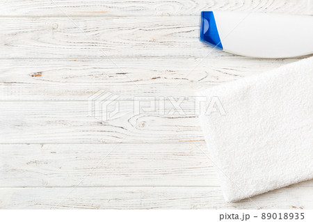 Cosmetic shampoo bottle mockup with towels on a colored table. Bathroom background, toilet accessories for hand and body care 89018935