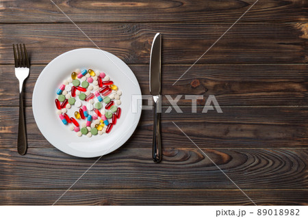 Many different weight loss pills and supplements as food on round plate. Pills served as a healthy meal. Drugs, pharmacy, medicine or medical healthycare concept Many different weight loss pills and supplements as food on round plate. Pills served as a healthy meal. Drugs, pharmacy, medicine or medical healthycare concept 89018982