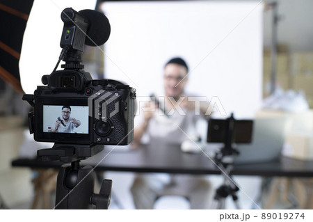 Asian man blogger or vlogger looking at camera reviewing product 89019274