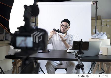 Asian man blogger or vlogger looking at camera reviewing product Asian man blogger or vlogger looking at camera reviewing product 89019276