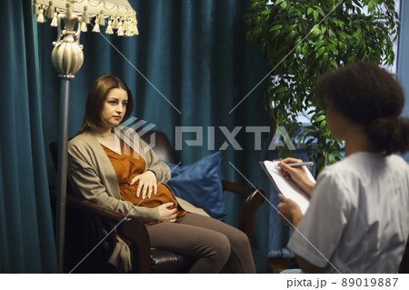 Happy young Caucasian pregnant woman talk consult with gynecologist in private clinic or hospital 89019887
