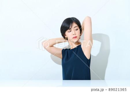 タンクトップで太陽光を浴びる女性 89021365