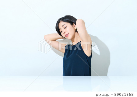 タンクトップで太陽光を浴びる女性 89021368
