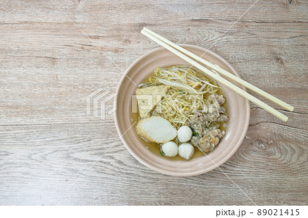 egg yellow noodles topping chop boiled pork and fish ball in soup on bowl 89021415