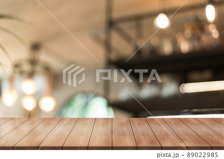 Empty wooden table top with lights bokeh on blur restaurant background. Empty wooden table top with lights bokeh on blur restaurant background. 89022985