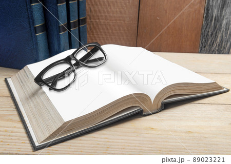 Closeup view of eyeglasses and the opened book Closeup view of eyeglasses and the opened book 89023221