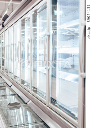 Empty refrigerator or freezer for food and grocery items in store. Selective focus, vertical photo. 89024151