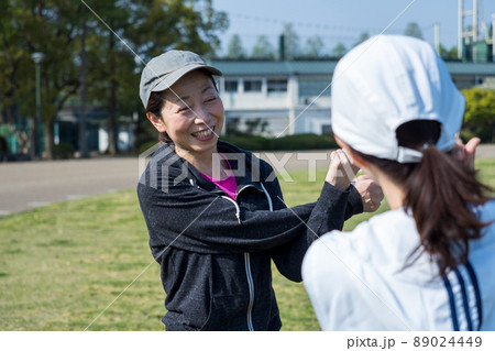 友人とジョギング前に準備運動するシニア女性 89024449