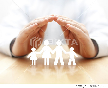 Family insurance concept with paper family cutout covered by hands 89024800