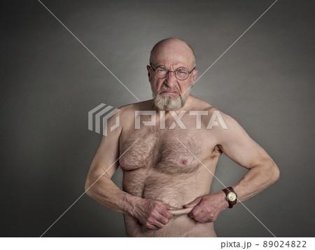 athletic senior man is not happy with his belly fat 89024822
