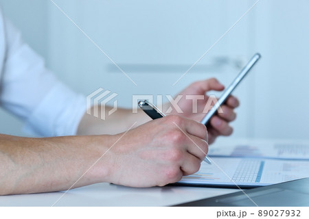 Manager checks the statistics on smart phone. 89027932