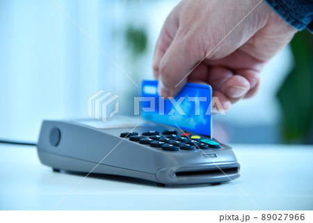 Close up of hand makes payment by blue credit card. 89027966