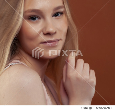 young pretty girl with blond hair posing cheerful on brown background, lifestyle people concept young pretty girl with blond hair posing cheerful on brown background, lifestyle people concept 89028261