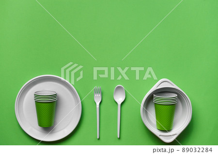 Colorful plastic disposable tableware on green background with copy space. The concept of picnic utensil. Top view. Selective focus. Close-up. Colorful plastic disposable tableware on green background with copy space. The concept of picnic utensil. Top view. Selective focus. Close-up. 89032284
