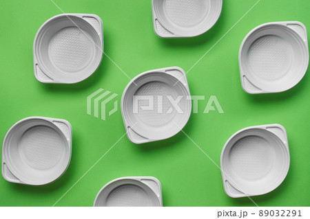 White plastic disposable tableware on green background with copy space. The concept of picnic utensil. Top view. Selective focus. Close-up. White plastic disposable tableware on green background with copy space. The concept of picnic utensil. Top view. Selective focus. Close-up. 89032291