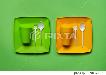 Colorful plastic disposable tableware on green background with copy space. The concept of picnic utensil. Top view. Selective focus. Close-up. Colorful plastic disposable tableware on green background with copy space. The concept of picnic utensil. Top view. Selective focus. Close-up. 89032292