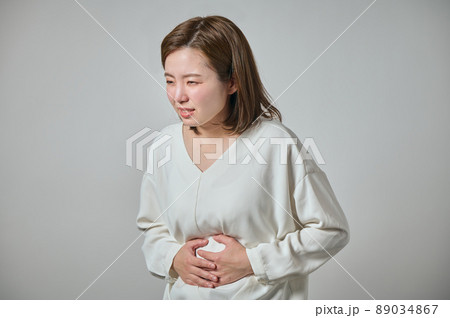 お腹が痛くて手でおさえる若い女性 89034867