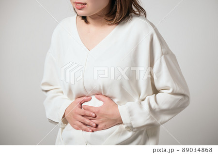 お腹が痛くて手でおさえる若い女性 89034868