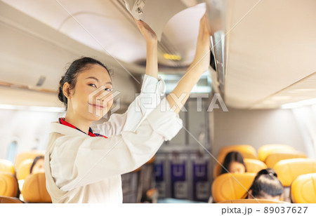 Inside an airplane, a beautiful air stewardess 89037627