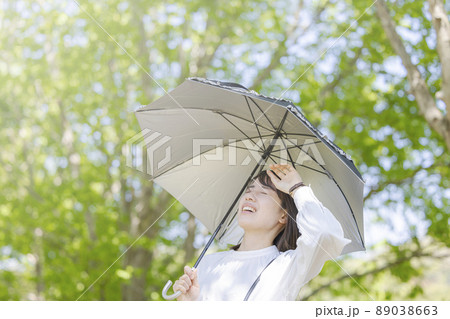 強い日差しの下で日傘をさす女性 強い日差しの下で日傘をさす女性 89038663