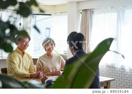 営業職の男性と自宅で会話をする年輩の夫婦 営業職の男性と自宅で会話をする年輩の夫婦 89039184