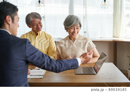 営業職の男性と自宅で会話をする年輩の夫婦 営業職の男性と自宅で会話をする年輩の夫婦 89039185