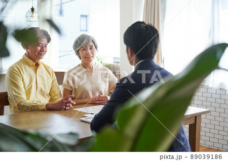 営業職の男性と自宅で会話をする年輩の夫婦 89039186