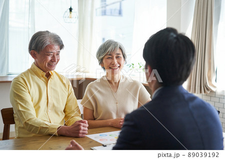 営業職の男性と自宅で会話をする年輩の夫婦 営業職の男性と自宅で会話をする年輩の夫婦 89039192