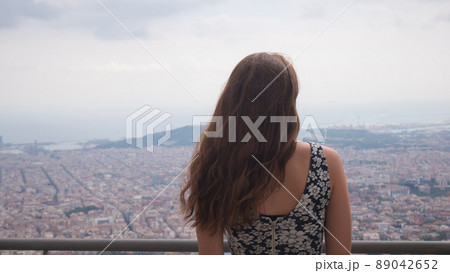 Girl staying on observation deck. Barcelona city aerial view. City overview. Girl staying on observation deck. Barcelona city aerial view. City overview. 89042652