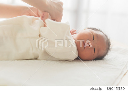 肌着を着せられる赤ちゃん　新生児　コピースペース 89045520