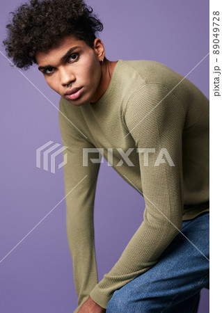 Young transgender man sits in t-shirt and blue jeans verticale portrait. Sensual trans gender male 89049728