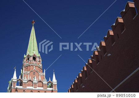 View of the Trinity tower of the Moscow Kremlin with a fortress wall on a Sunny spring day. World tourism, sights of Moscow. High quality photo 89051010