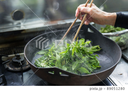 炮烙鍋でお茶の葉を蒸しているシニア女性 89051280
