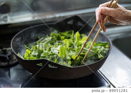 炮烙鍋でお茶の葉を蒸しているシニア女性 89051281