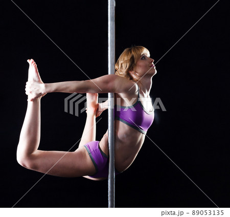 The strong and graceful young girl performing acrobatic exercises on pylon The strong and graceful young girl performing acrobatic exercises on pylon 89053135
