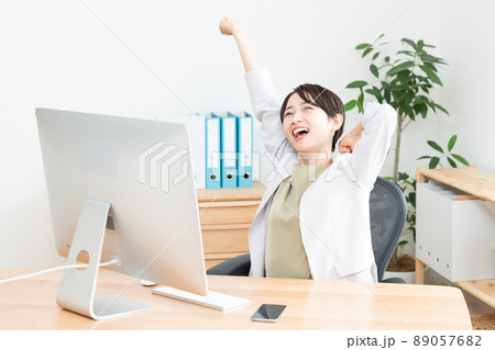 伸びをするオフィスで働く女性（ビジネス・ビジネスマン・ビジネスウーマン・OL・仕事・パソコン） 89057682