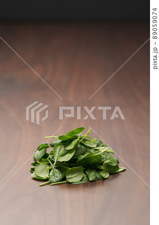 Fresh spinach leaves on walnut wood table Fresh spinach leaves on walnut wood table 89059074