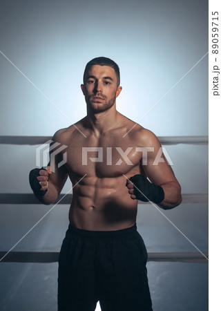 Boxer, man posing in bandage on boxing ring. Fitness and boxing concept.  89059715