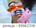 Woman patient with protective glasses for teeth whitening procedure. 89062336