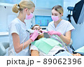 Orthodontist and assistant scaning patient's teeth with intraoral 3d scanner 89062396